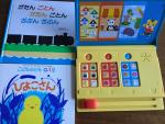 幼児向け絵本２冊、日本語おもちゃコンピュータ（子供チャレンジ、しまじろうから）に関する画像です。